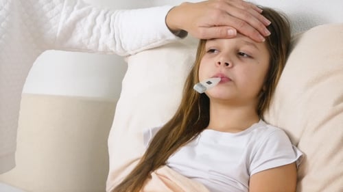 Sick Child Taking Temperature Lying in Bed