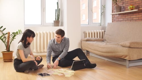 Man and Woman Brainstorming Together on the Floor