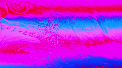 Makroaufnahme einer pinkfarbenen Flüssigkeit, die einen abstrakten Effekt von der Oberfläche der Seife erzeugt