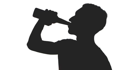 Silhouette of man drinking beer from bottle