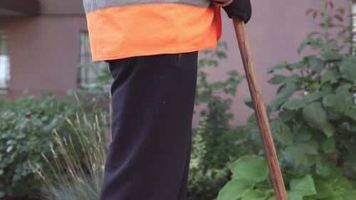 Un concierge de rue ramasse les ordures. La propreté et l'ordre dans la cour dépendent du concierge.
