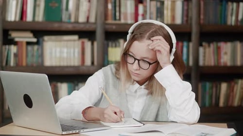 Teen Student Studying at Library Desk with Laptop