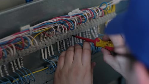 Technician Working on Electrical Wiring with Screwdriver