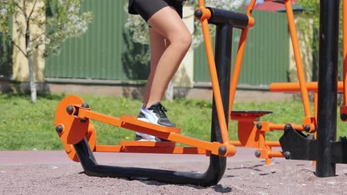 Woman Exercising on Elliptical Machine at Outdoor Park