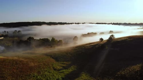 Foggy Sunrise Over Rolling Hills in Rural Landscape