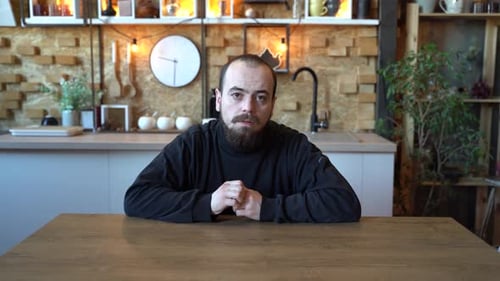 Man in Black Sweater Sitting at Table