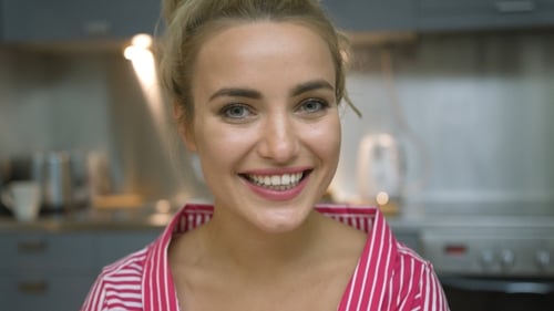 Woman Smiles in a Modern Kitchen Setting