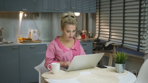 Young Woman Using Laptop in Kitchen