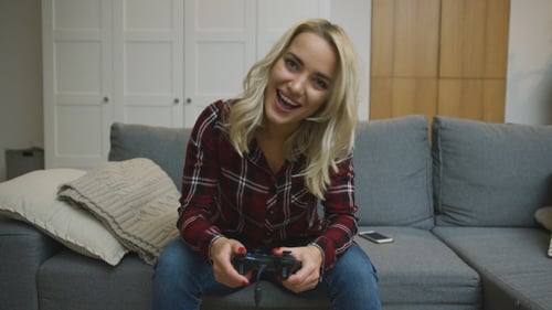 Woman Playing Video Game on Couch Indoors