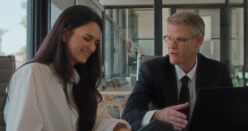 Close up of two business partners having a meeting in an office to discuss a new project.Slow motion