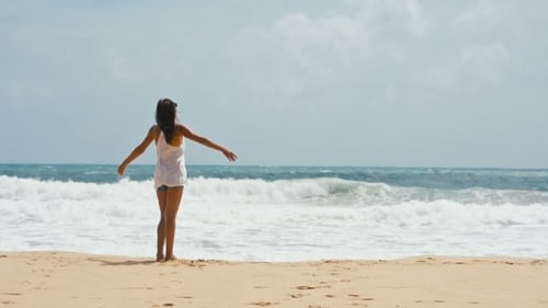 Young Woman Lifts Hands Up on the Sea Background