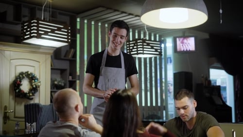 the Waiter Takes an Order From a Group of People Who Chose Food From the Menu