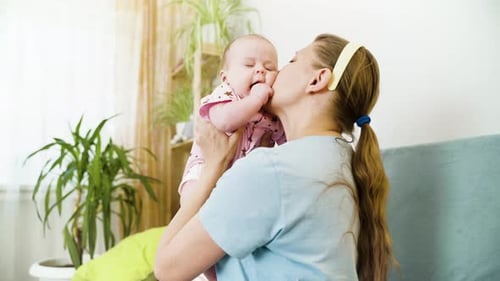 Loving Mother Holding Baby Up at Home