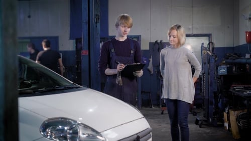Young Technician Man with Tablet and Customer Woman Standing at Car