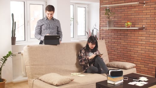 Woman Using Tablet in Living Room With Man