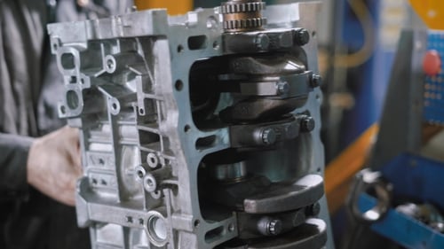 Mechanic Is Repairing Car Engine in a Workshop, Tightening Bolts, Using Wrench, of a Crankshaft