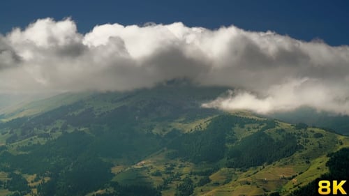 Lush Green Hills and Clouds Aerial View