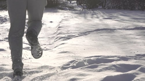 Man Is Running Through the Deep Snow