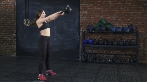 Fitness Woman Doing Kettlebell Swings in Gym