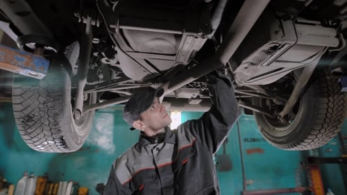 Adult Man Checks the Condition of the Vehicle in a Tire Service Shop
