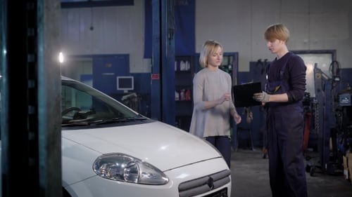 Professional Mechanic Gives the Customer a Car That Was Repaired in a Car Workshop