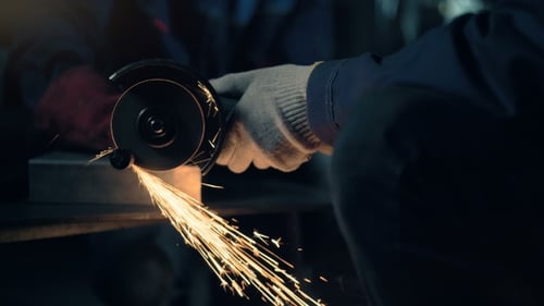 Worker Cuts Metal with Hand Disc Grinder Abrasive Saw