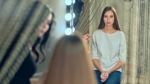 Makeup Artist Applying Lipstick to a Beautiful Woman