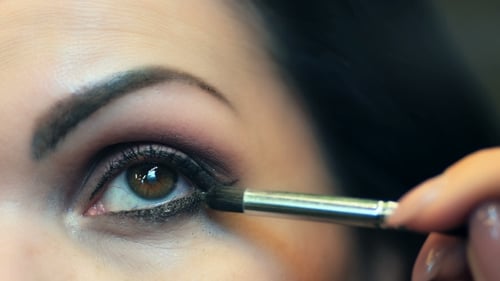 Female Eye with Bright Make-up and Brush Applying Mascara on Eyelashes