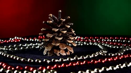 Tannenzapfen für Weihnachten oder Neujahr und Perlen, Rotation, auf Rot und Grün