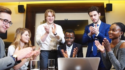 Diverse Team Celebrates Success in Modern Office