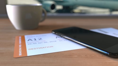 Boarding Pass To Paris and Smartphone on the Table in Airport While Travelling To France