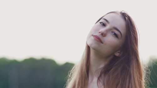 Beautiful Young Girl with Long Hair Posing on the Camera on a Nature Background and Forest. Face of