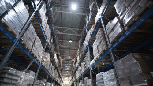 La caméra se déplace sur les étagères des boîtes en carton à l'intérieur d'un entrepôt de stockage