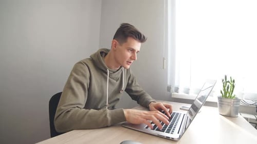 Young Businessman Works on Laptop