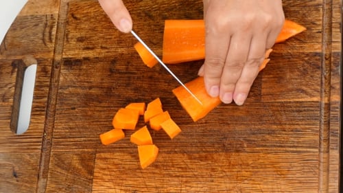 Dicing Carrots on a Wooden Cutting Board