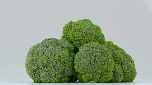 Close-up of Fresh Broccoli Rotating on White Surface