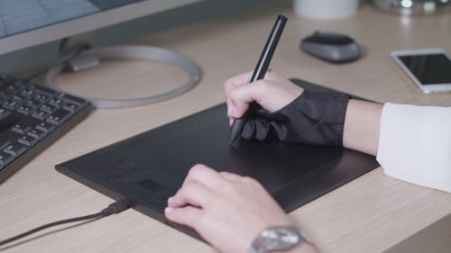 Digital Artist Using Graphic Tablet at Desk