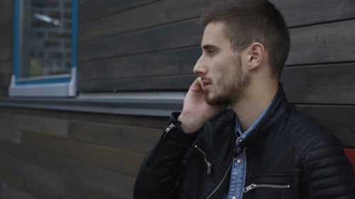 Stylish Man Speaking at Smartphone at Wooden Building