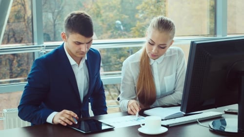 Two Young Men Working in the Office. Successful Transaction