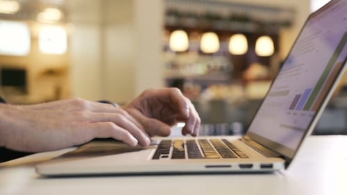 Businessman Working at Laptop in Business Center and Analyzes Charts and Graphs