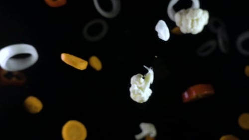 Floating Vegetables Bounce in Slow Motion on Black