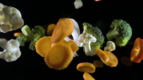 Fliegendes Gemüse isoliert auf schwarzem Hintergrund.