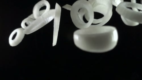 Falling Onion Rings in Slow Motion on Black