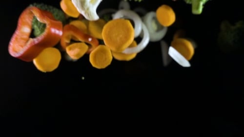 Fliegendes Gemüse isoliert auf schwarzem Hintergrund.