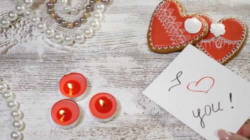 St Valentine Day Background Two Heart Shaped Ginger Biscuits, Tea Candles and Pearl Beads on