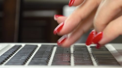 Woman with Red Nails Typing on Laptop