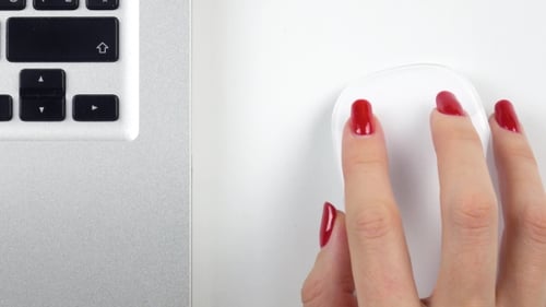 Woman's Right Hand with Red Manicure Using a Wireless Computer Mouse. Top View.