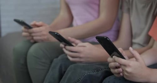 Teens and Young Adult Using Phones on Couch
