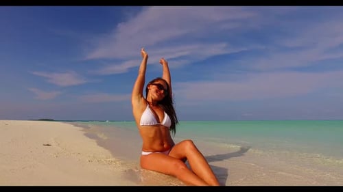 Female model tans on idyllic sea view beach journey by blue ocean with bright sandy background of th