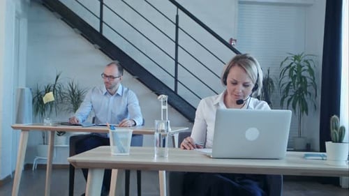 Beautiful Call Center Agent Having Phone Call and Browsing the Internet on Her Computer